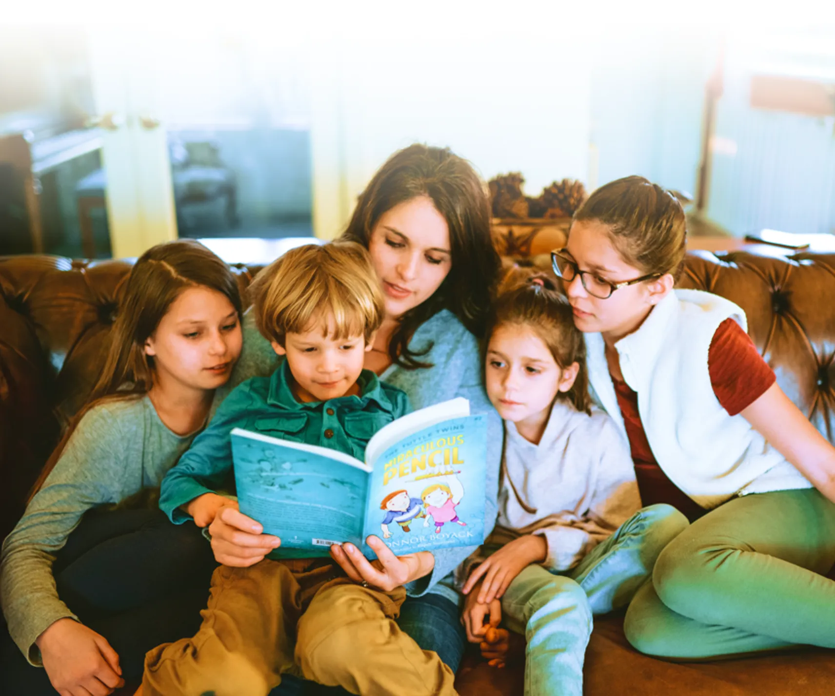 Family and children sitting together while reading a Tuttle Twins book.